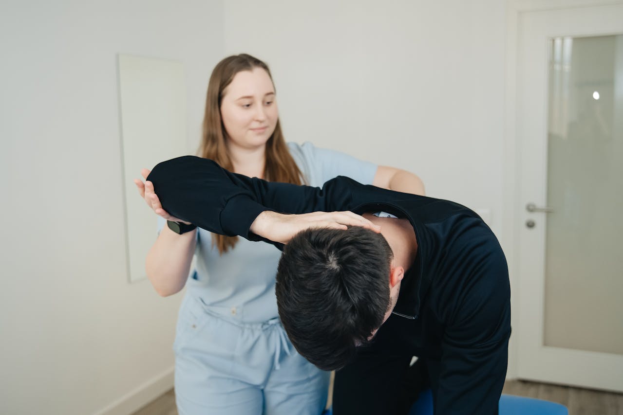 A physiotherapist assisting a client with a neck exercise to improve mobility and reduce pain.