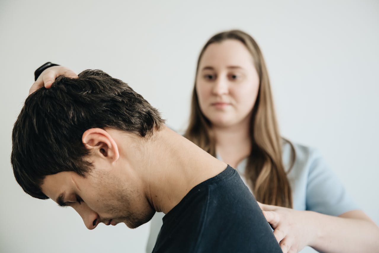A physiotherapist assessing a client’s condition during a physiotherapy session.
