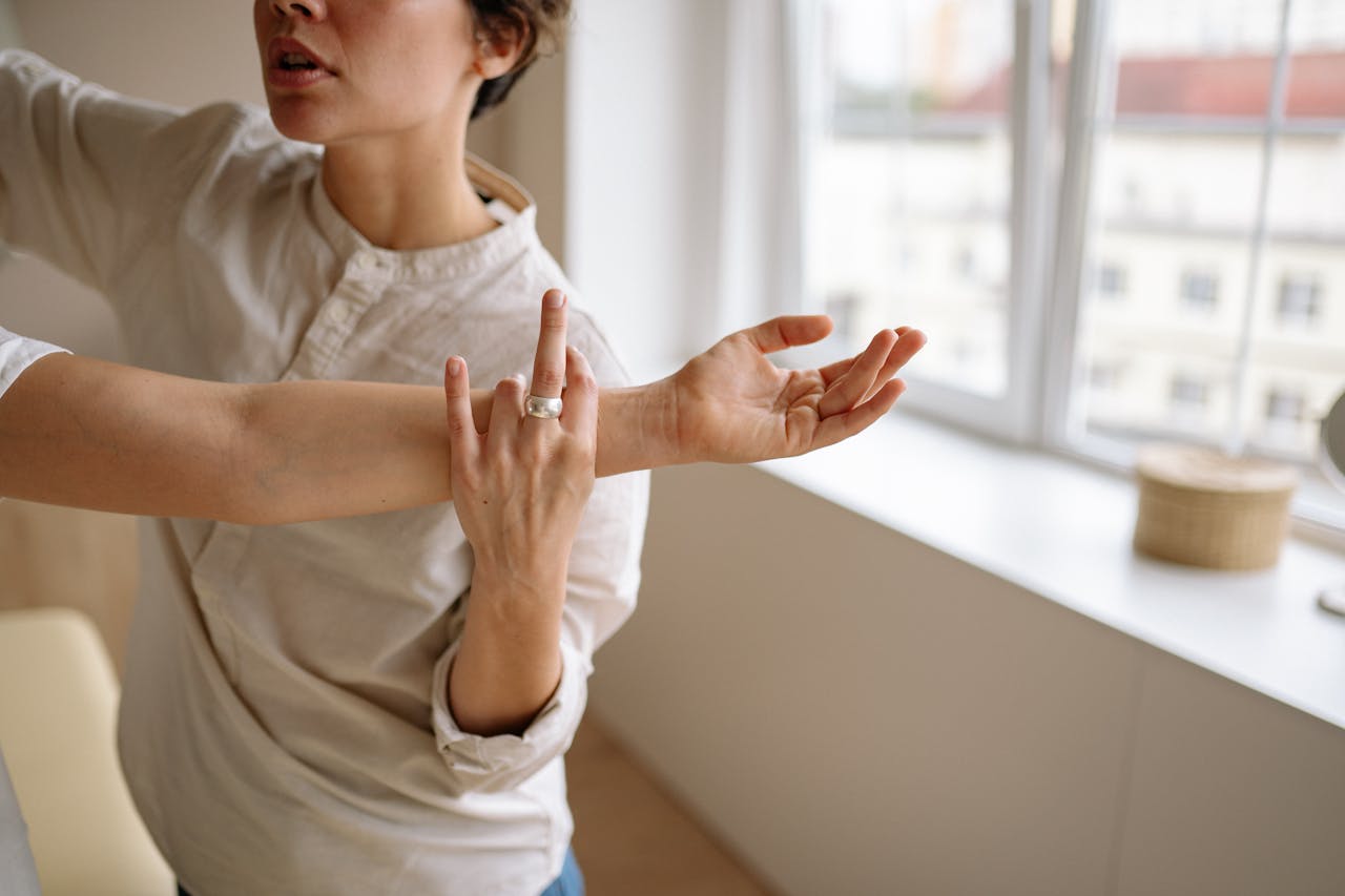 Close-up of a physiotherapist performing palpation on a patient's arm to assess muscle and joint condition.