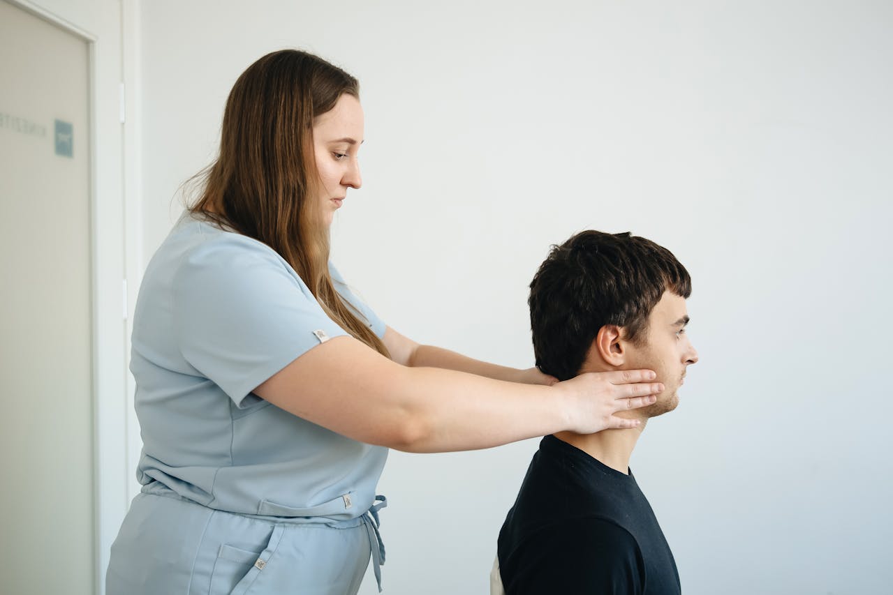 A physiotherapist helping a client with a head support technique in a clinical Pilates session.