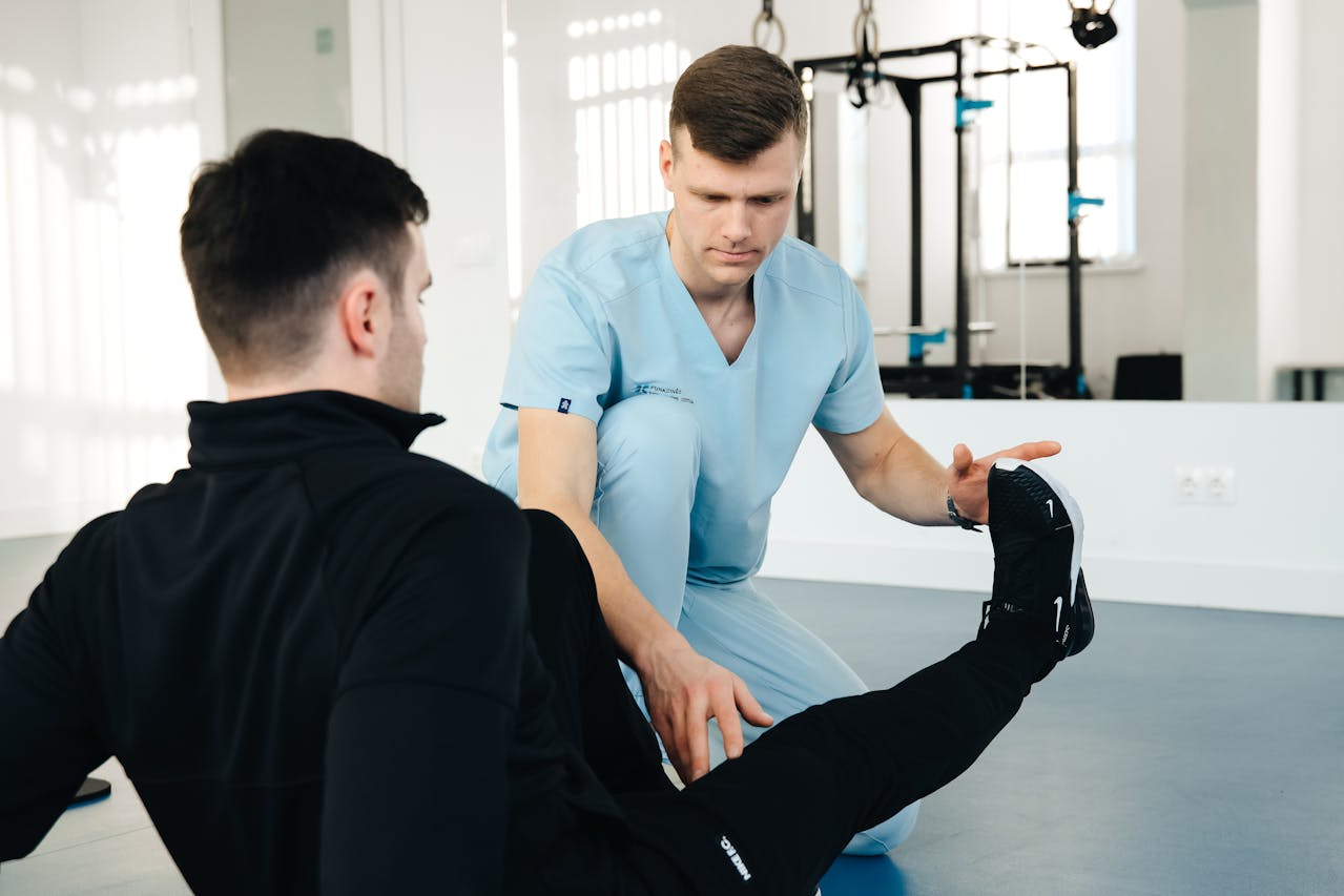 A physiotherapist guiding a patient through a seated Pilates exercise to enhance core strength.